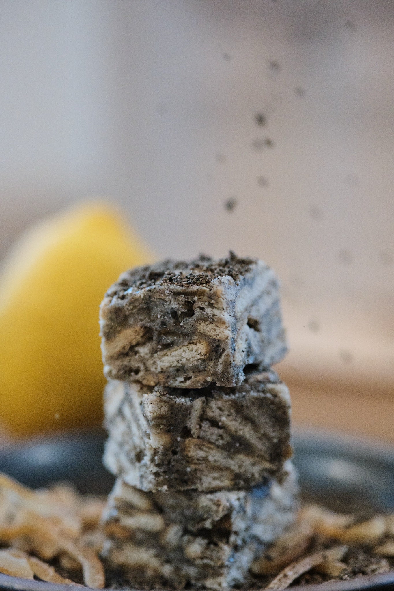 Black Sesame Yuzu Snowcubes — ground black sesame sprinkling down onto a stack of crisps