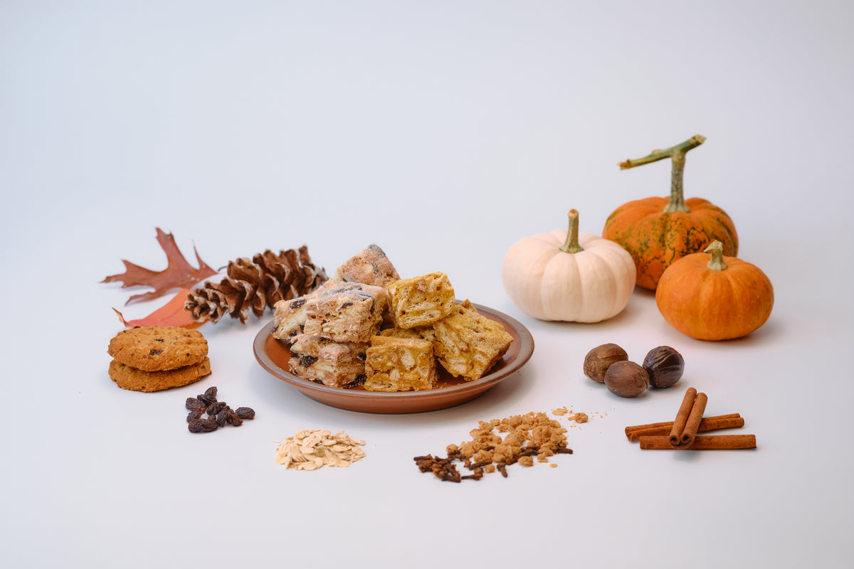Pumpkin Pie and Oatmeal Raisin Crumble Snowcubes on a plate with pumpkins, oats, raisins, cloves, and cinnamon