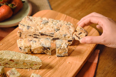 A hand lifting a Cherry Oreo snowflake crisp from the cutting board