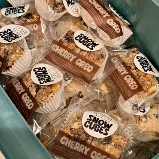 A mint box packed with individually wrapped Snowcubes, Cherry Oreo and Classic labels facing up