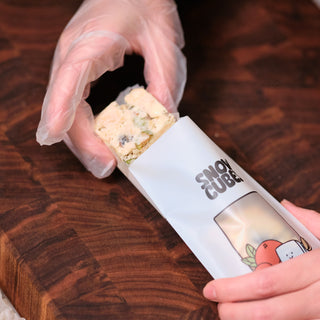 Gloved hands placing a Snowcubes cube into its pouch