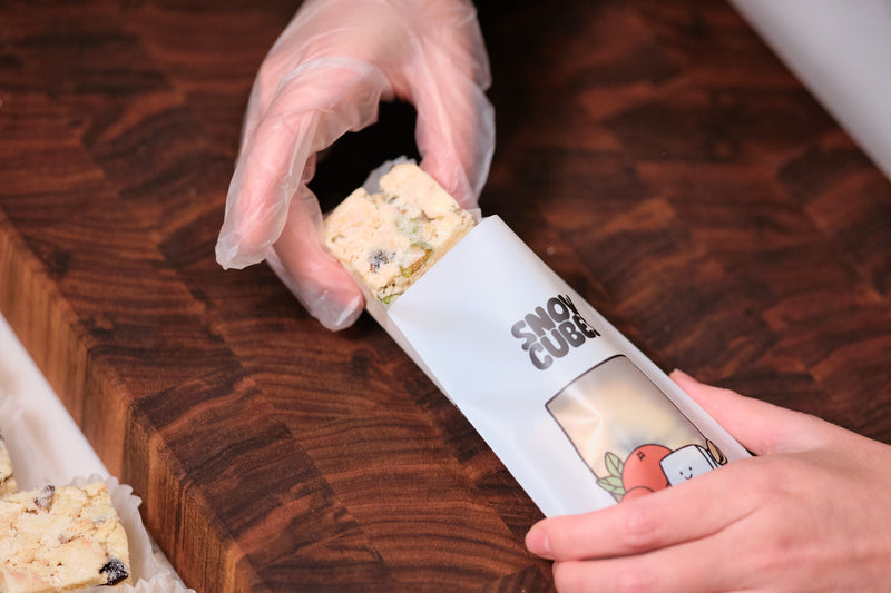 Gloved hands placing a Snowcubes cube into its pouch