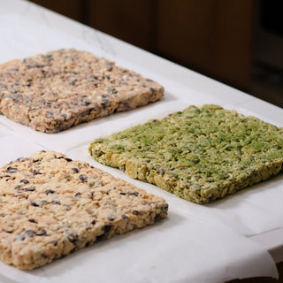 Three uncut Snowcubes slabs cooling on parchment, one dusted green with matcha