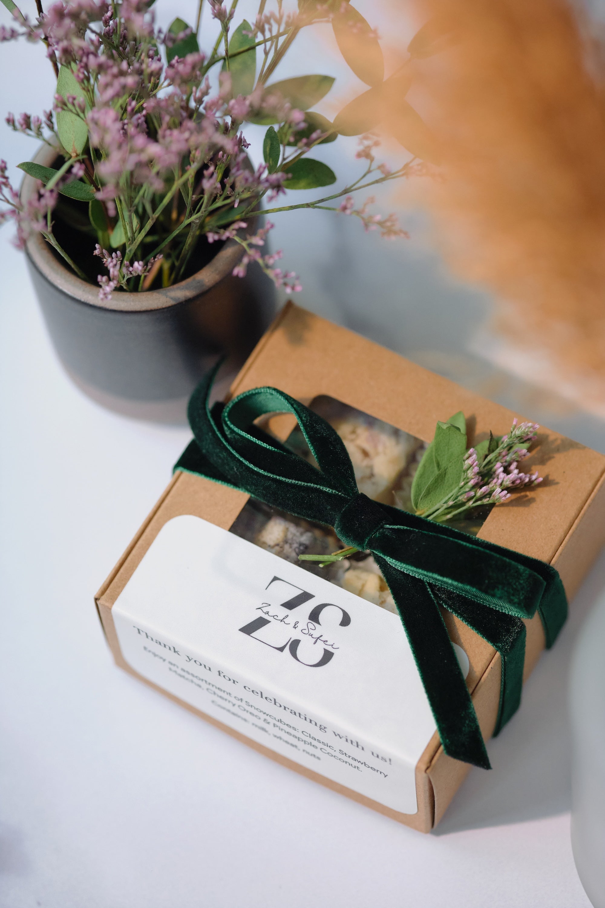 A Snowcubes wedding favor box with ribbon and small florals, made for a planner's couple